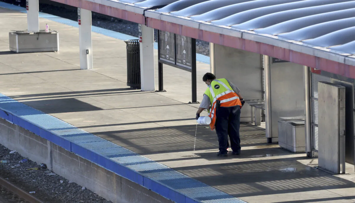 A CTA employee cleans up the platform of a closed off 63rd St. CTA Red Line station following an early morning fatal stabbing on a CTA train in Chicago on July 25, 2022. (Antonio Perez/Chicago Tribune via AP)