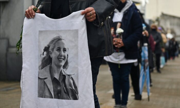 A young Peronist holds a shirt with the picture of former First Lady (1946-1952) Eva Peron at the Recoleta cemetery in Buenos Aires, on July 26, 2022, during the 70th anniversary of her death. (Luis Robayo/AFP via Getty Images)