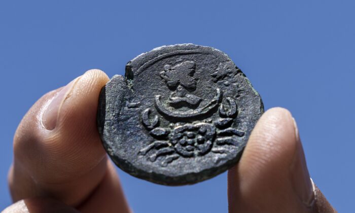 A rare, nearly 1,850-year-old bronze coin discovered off the Israeli coastal city of Haifa is on display at Israel's Antiquities Authority office in Jerusalem, on July 26, 2022. (Tsafrir Abayov/AP Photo)