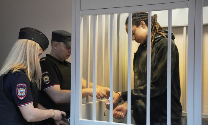A policeman removes the handcuffs from WNBA star and two-time Olympic gold medalist Brittney Griner in a courtroom prior to a hearing, in Khimki just outside Moscow, Russia, on Tuesday, July 26, 2022. (Alexander Zemlianichenko/AP Photo)