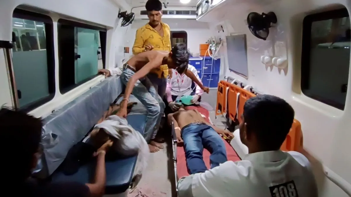 People wait to be carried into a hospital for treatment after falling sick from consuming spurious liquor in Botad, India, on July 26, 2022. (AP Photo)