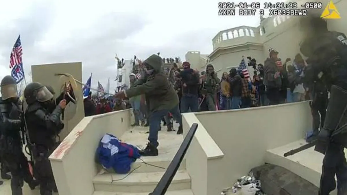 In this image from video, Mark Ponder (C) strikes a U.S. Capitol Police officer on Jan. 6, 2021. (Department of Justice via The Epoch Times)