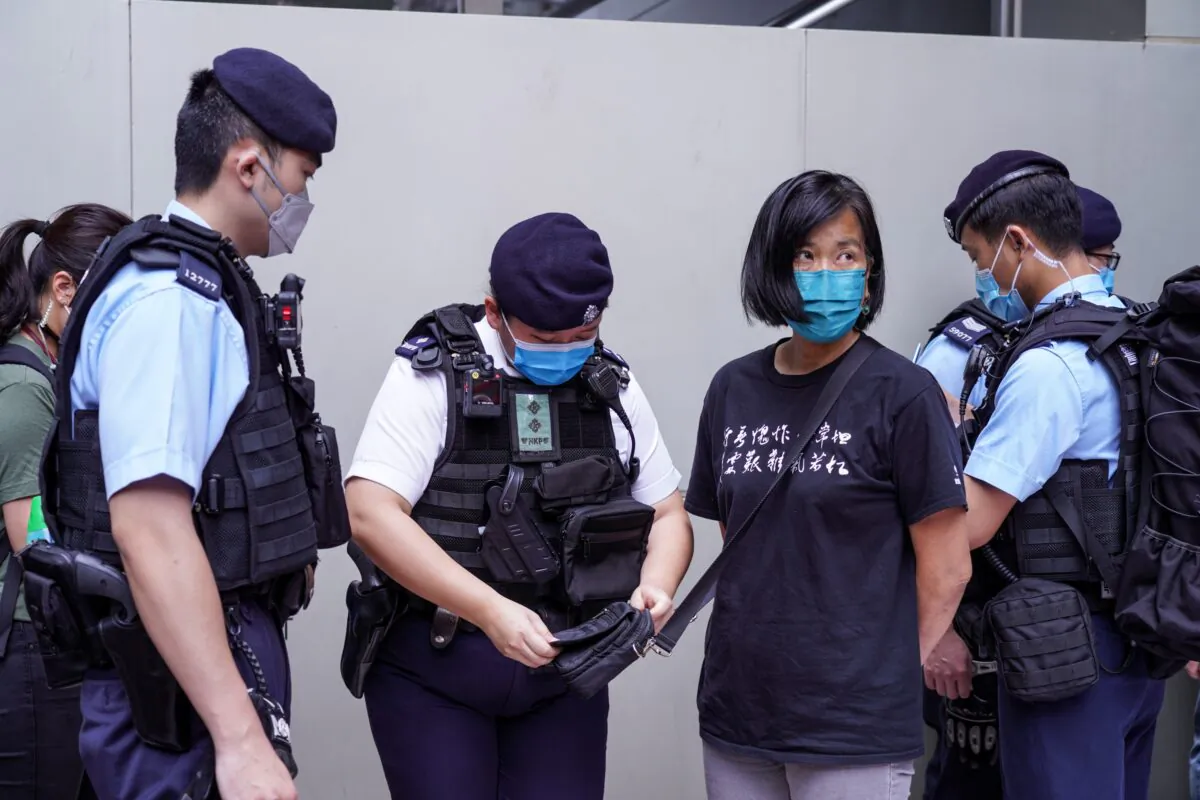 During the 6th Chief Executive Election, Chan Po-ying and her colleagues of the League of Social Democrats marched to the polling station at Wanchai Convention and Exhibition Center to protest against the small circle election, but they were stopped by the police at Central Plaza, in Hong Kong on May 8, 2022. (Adrian Yu/The Epoch Times)