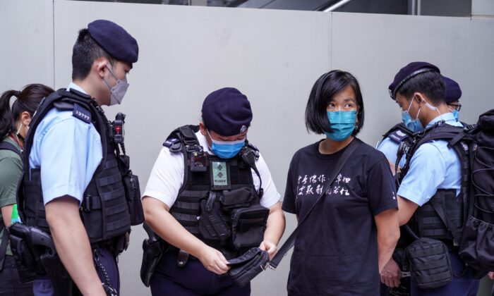 During the 6th Chief Executive Election, Chan Po-ying and her colleagues of the League of Social Democrats marched to the polling station at Wanchai Convention and Exhibition Center to protest against the small circle election, but they were stopped by the police at Central Plaza, in Hong Kong on May 8, 2022. (Adrian Yu/The Epoch Times)