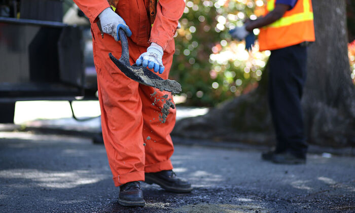 Workers fix a pothole in Oakland, Calif. on April 29, 2013. (Justin Sullivan/Getty Images)
