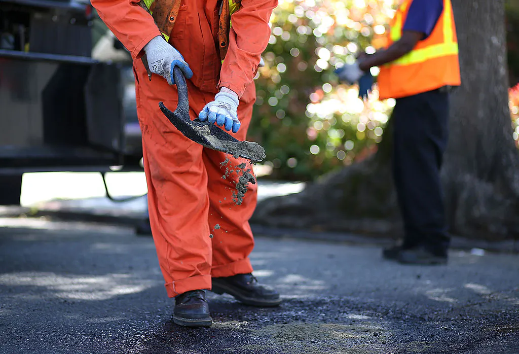 Workers fix a pothole in Oakland, Calif., on April 29, 2013. (Justin Sullivan/Getty Images)