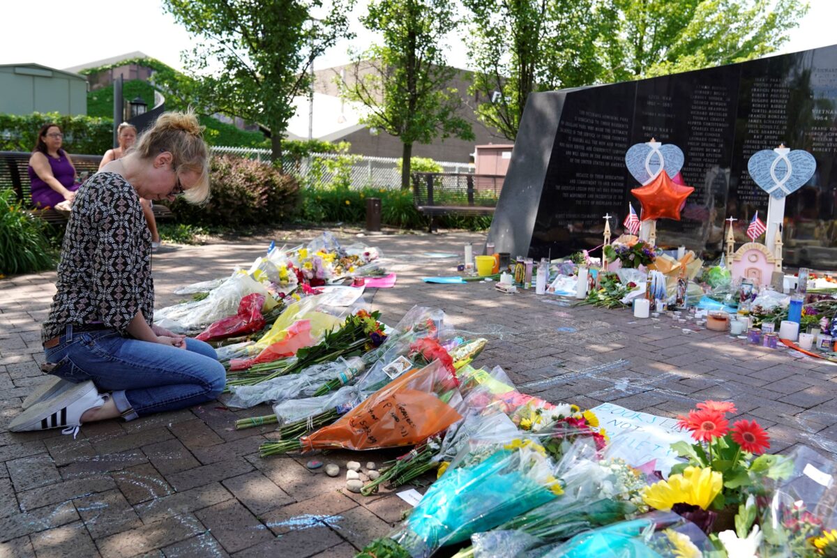 A visitor prays at a memorial to the seven people killed