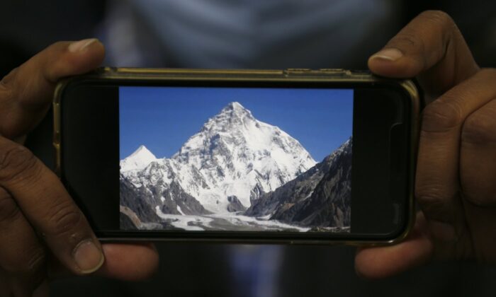 A photo of K2, the world's second-highest mountain, is displayed on a cellphone in Islamabad, Pakistan,  Feb. 9, 2021. (The Canadian Press/AP/Anjum Naveed)