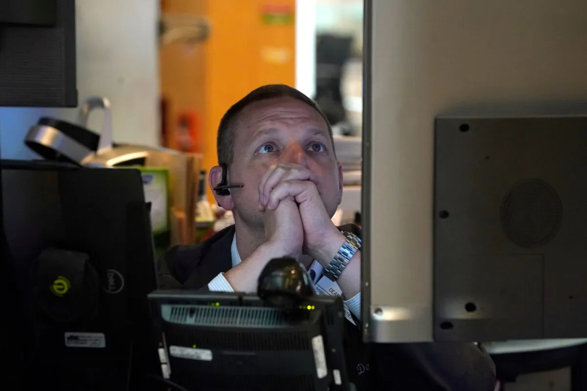 A person on the floor of the New York Stock Exchange (NYSE) watches TV screens on July 27, 2022. (Timothy A. Clary/AFP via Getty Images)
