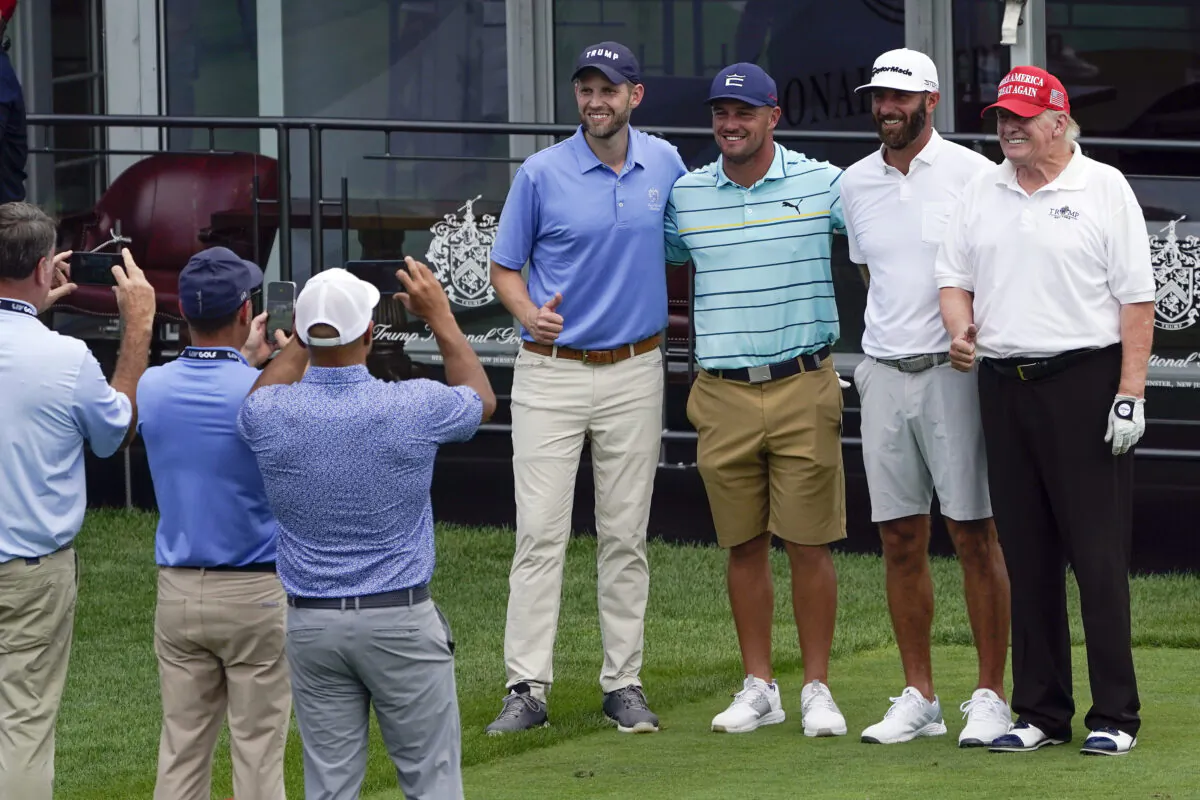Former President Donald Trump, right, golfer Dustin Johnson, second from right, golfer Bryson DeChambeau, third from right, and Eric Trump pose for a picture as they play together during the pro-am round of the Bedminster Invitational LIV Golf tournament in Bedminster, N.J., on July 28, 2022. (Seth Wenig/AP Photo)