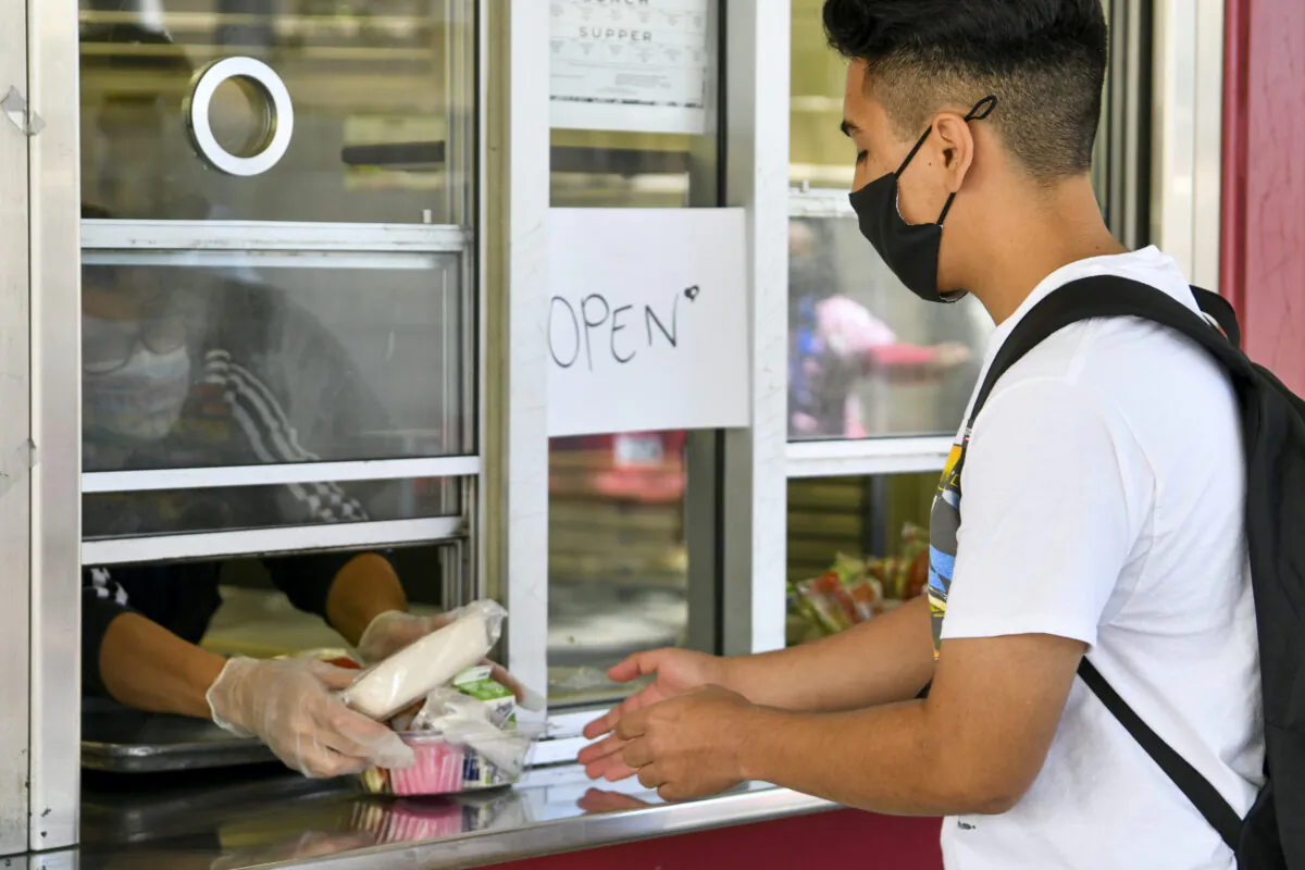 A student receives a pre-packaged lunch at Hollywood High School in Los Angeles on April 27, 2021. (Rodin Eckenroth/Getty Images)