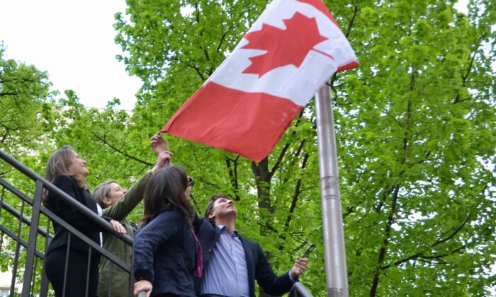 Deputy Prime Minister Chrystia Freeland, Foreign Minister Melanie Jolie, Canadian Ambassador to Ukraine Larissa Galaza and Prime Minister Justin Trudeau raise the flag at the Canadian Embassy in Kyiv, Ukraine, May 8, 2022.  (The Canadian Press/CBC News/Pool/Murray Brewster)