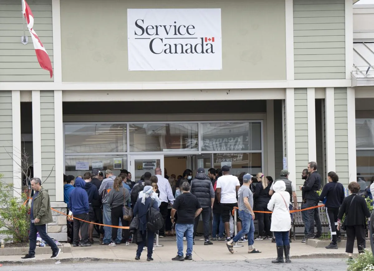 People line up at the passport office on June 21, 2022, in Laval, Que. (The Canadian Press/Ryan Remiorz)