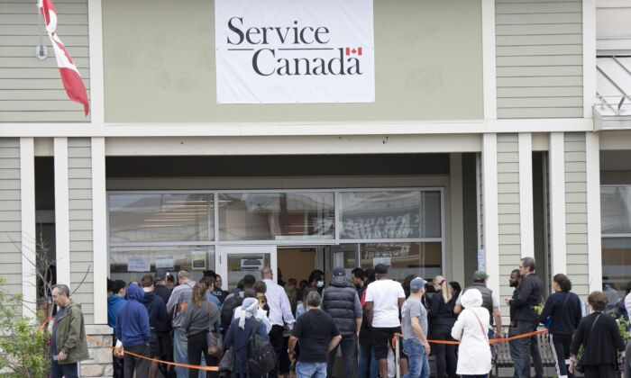People line up at the passport office, June 21, 2022 in Laval, Que. (The Canadian Press/Ryan Remiorz)