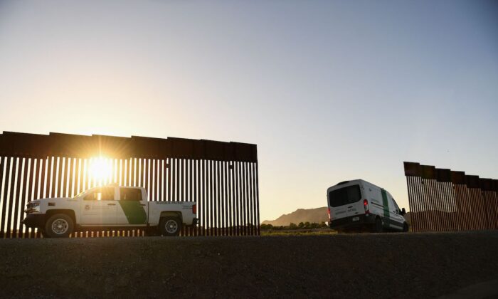 A Border Patrol agent drives a van between a gap along the border wall between the United States and Mexico in Yuma, Ariz., on June 1, 2022. (Patrick T. Fallon/AFP via Getty Images)