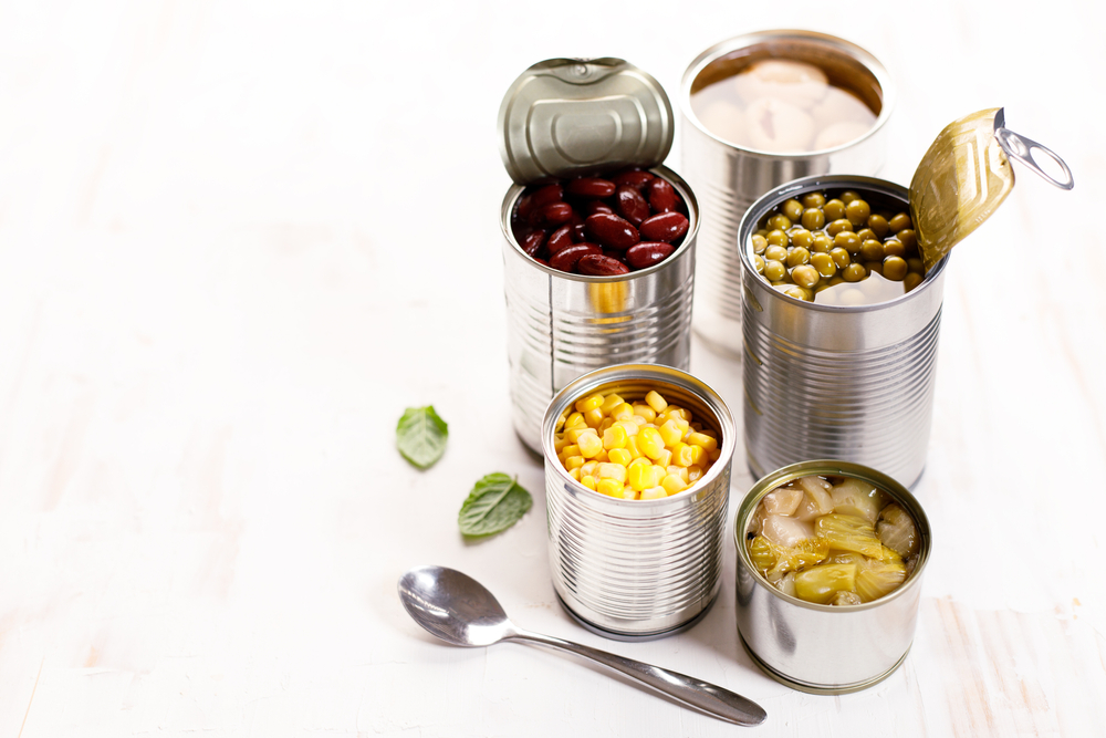 Different,Kinds,Of,Vegetables,In,Cans,On,Kitchen,Table,Background.