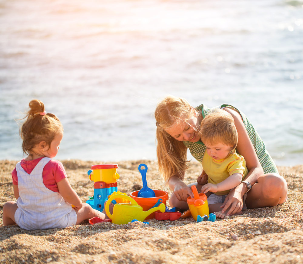 Mother,Playing,With,Children,On,The,Beach