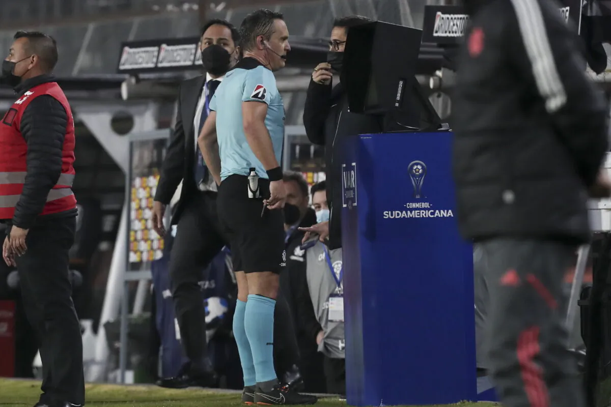 Referee Patricio Loustau of Argentina checks the VAR during a Copa Sudamericana soccer match between Chile's Colo Colo and Brazil's International in Santiago, Chile, on June 28, 2022. (Luis Hidalgo/AP Photo)