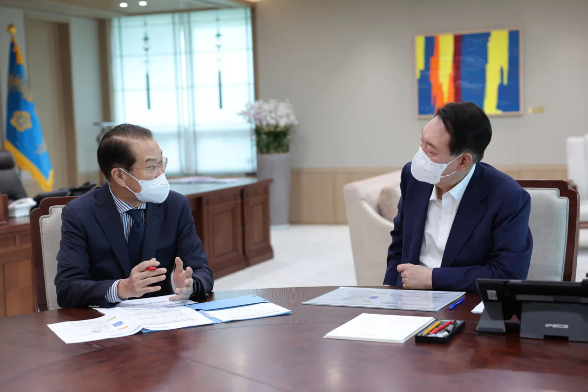 South Korean President Yoon Suk Yeol (R) listens to Unification Ministry's policy briefing by Unification Minister Kwon Youngse at the presidential office in Seoul, South Korea, on July 22, 2022. (South Korea Presidential Office via AP)