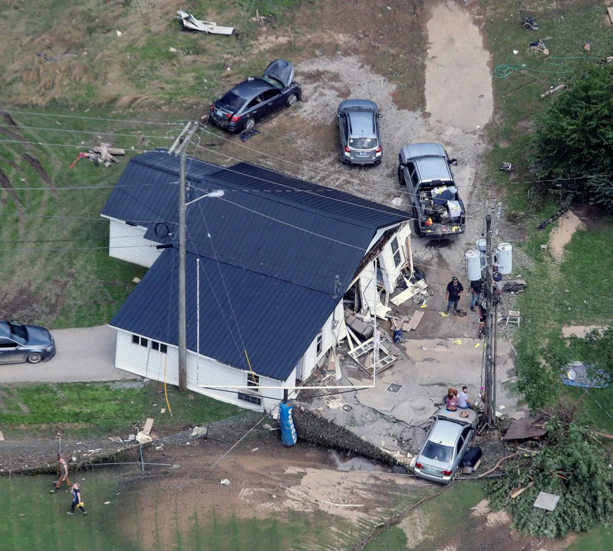 In this aerial image, a home in Eastern Kentucky is washed onto a road on July 30, 2022, after historic rains during the week flooded many areas of Kentucky. (Michael Clevenger/Courier Journal via AP)