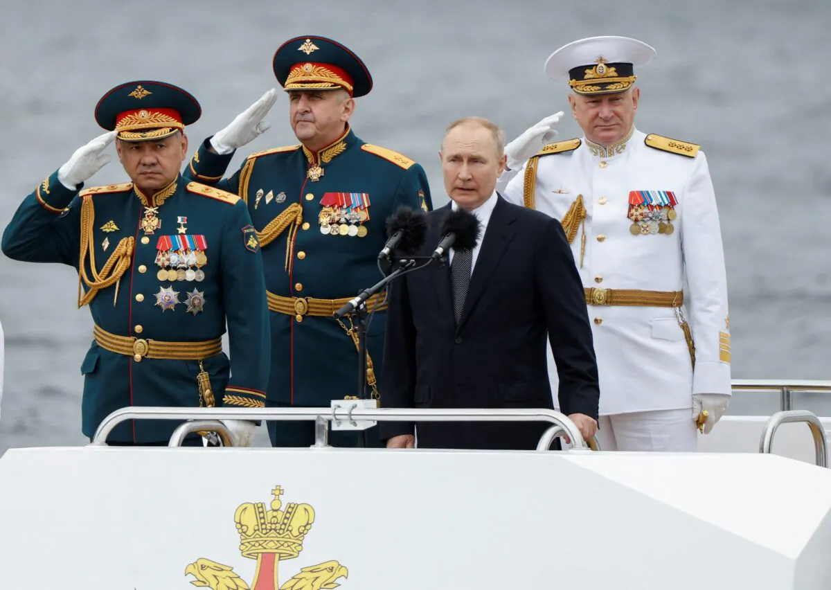 Russian President Vladimir Putin, Defense Minister Sergei Shoigu, and head of the Russian navy Adm. Nikolai Yevmenov attend a parade marking Navy Day in Saint Petersburg, Russia, on July 31, 2022. (Maxim Shemetov/Reuters)