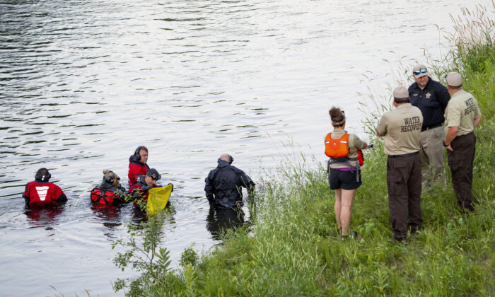 Water Recovery authorities comb the Apple River with metal detectors after five people were stabbed while tubing down the river in Somerset, Wis., on July 30, 2022. (Alex Kormann/Star Tribune via AP)
