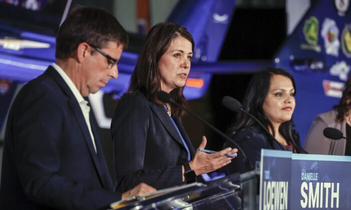Danielle Smith, centre, makes a comment as Todd Loewen, left, and Rajan Sawhney listen during the United Conservative Party of Alberta leadership candidate's debate in Medicine Hat, Alta., on July 27, 2022. (Jeff McIntosh/The Canadian Press)