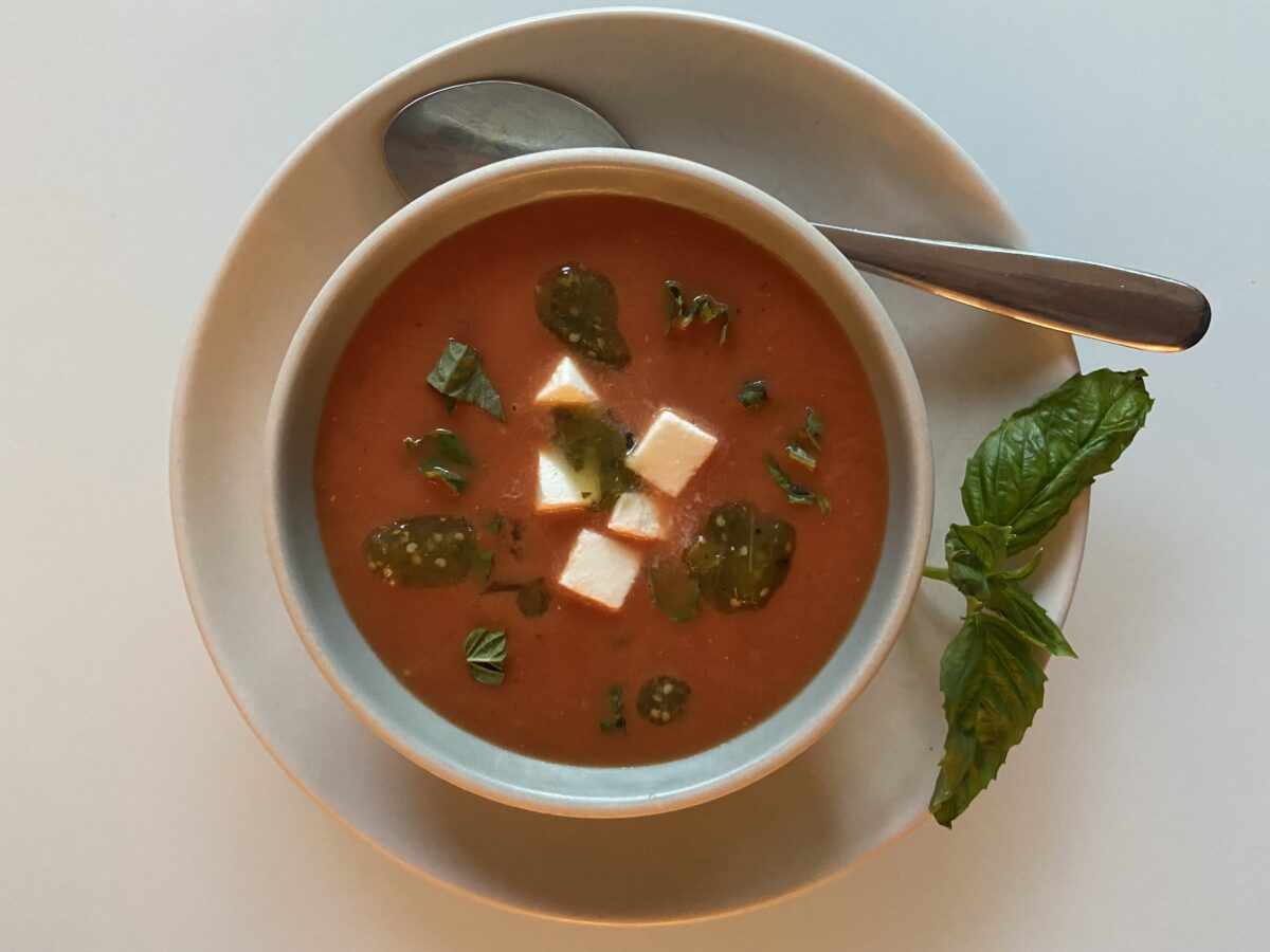 This roasted tomato soup can be served hot or cold, topped with basil, fresh mozzarella, and dollops of tomatillo salsa. (JeanMarie Brownson/TNS)