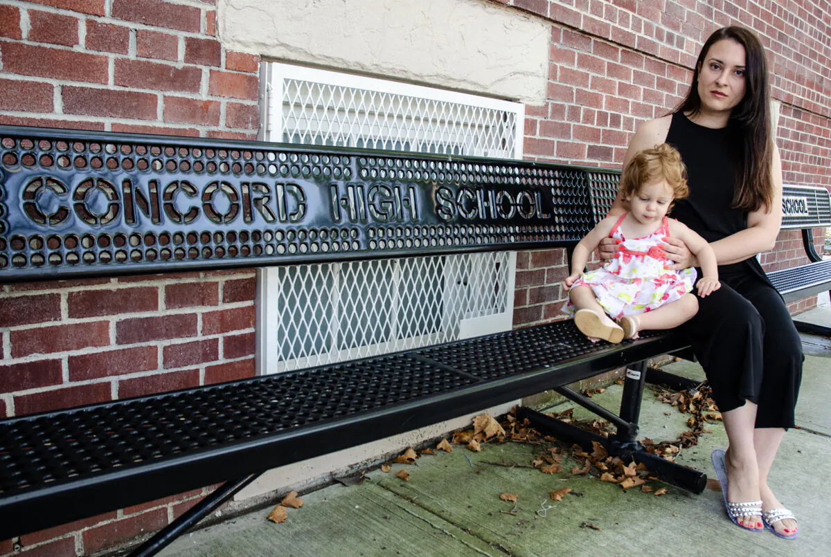 Unvaccinated English and special education teacher, Rachel Maniscalco, and her daughter Julia, in front of her former place of employment, Concord High School in Staten Island, New York, on August 2, 2022. (Dave Paone/The Epoch Times)