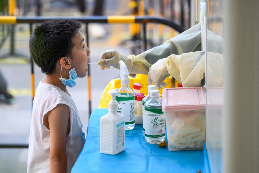 A health worker is taking a swab sample from a child to be tested for COVID-19 in Guangzhou, in China's southern Guangdong Province on July 31, 2022. (STR/AFP via Getty Images)