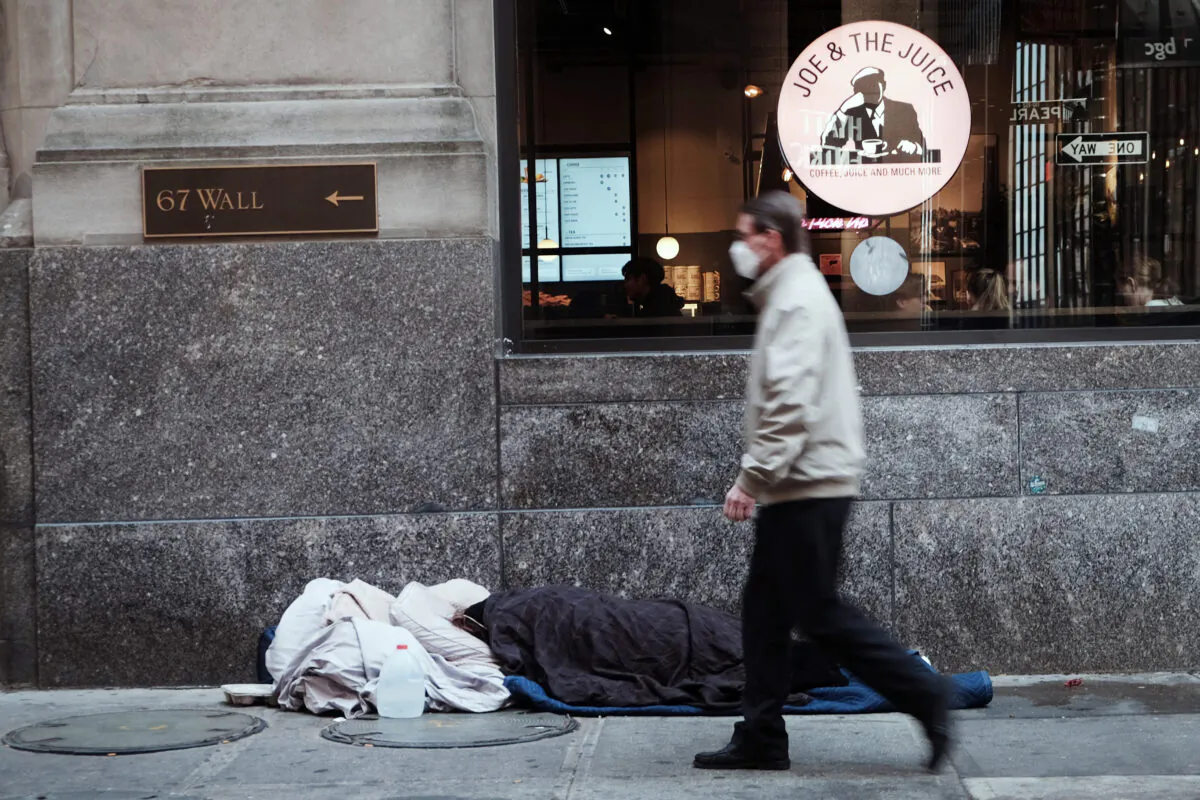 A homeless person sleeps along Wall Street in New York City, on April 28, 2022. (Spencer Platt/Getty Images)