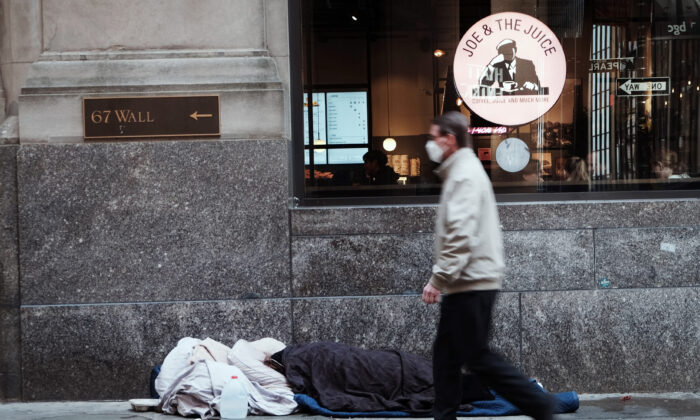 A homeless person sleeps along Wall Street in New York City, on April 28, 2022. (Spencer Platt/Getty Images)