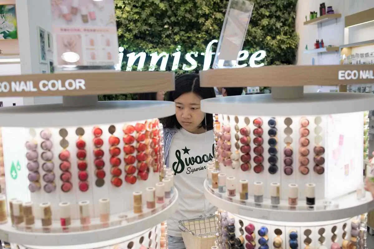 A woman looks at lipstick at a shopping mall in Beijing on May 10, 2018. (Nicolas Asfouri/AFP via Getty Images)