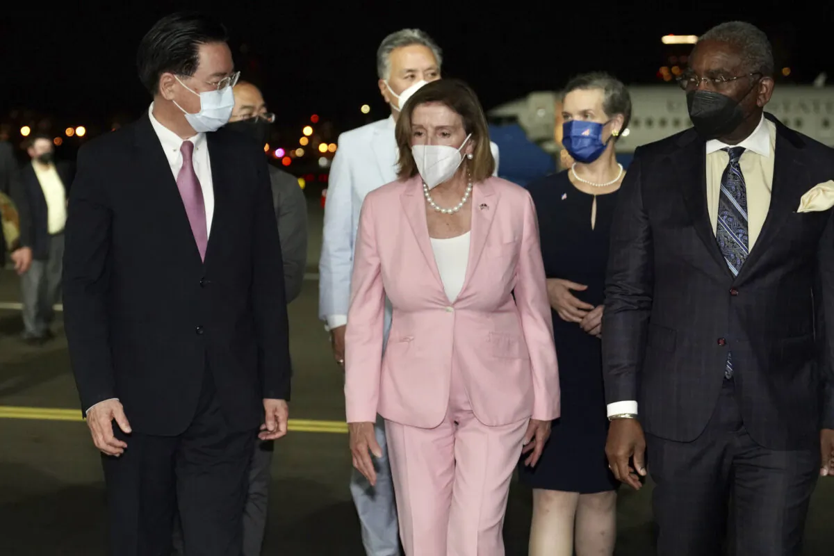 U.S. House Speaker Nancy Pelosi (C) walks with Taiwan's Foreign Minister Joseph Wu (L) as she arrives in Taipei, Taiwan, on Aug. 2, 2022. (Taiwan Ministry of Foreign Affairs via AP)