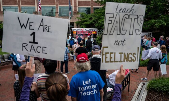 People hold up signs during a rally against critical race theory (CRT) being taught in schools at the Loudoun County Government center in Leesburg, Virginia on June 12, 2021. (Andrew Caballero-Reynolds/AFP via Getty Images)