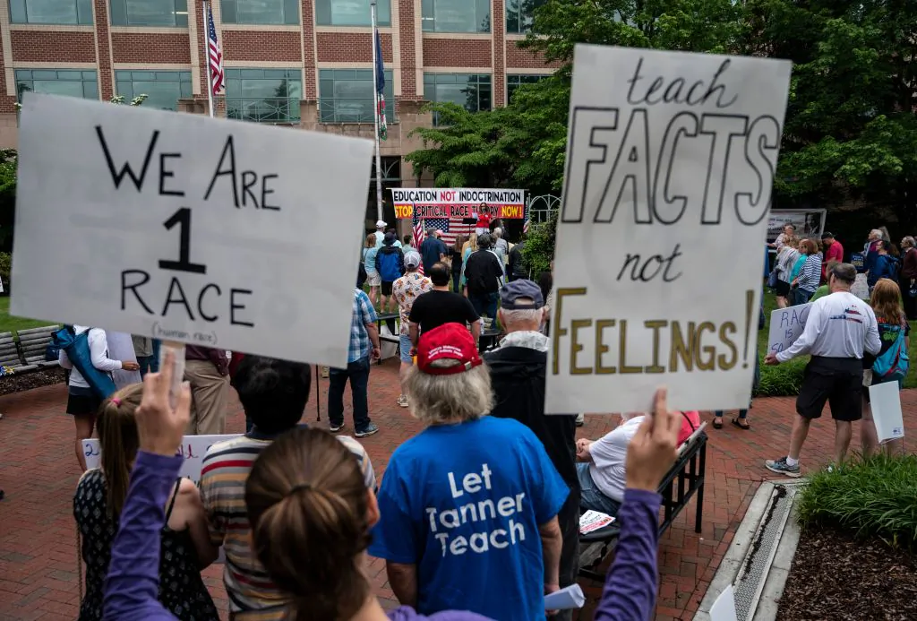 People hold up signs during a rally against critical race theory (CRT) being taught in schools at the Loudoun County Government center in Leesburg, Virginia on June 12, 2021. (Andrew Caballero-Reynolds/AFP via Getty Images)