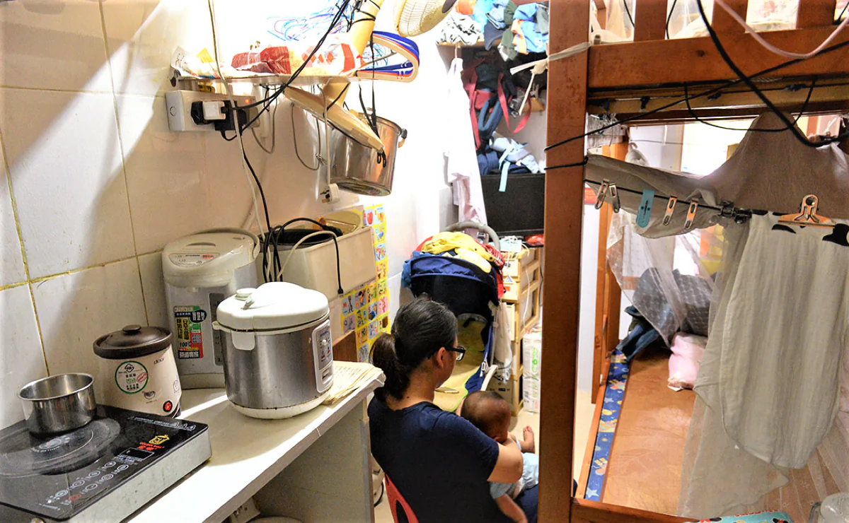 A woman and a child in a subdivided unit in Hong Kong on Aug. 3, 2022. (Sung Pi-lung / The Epoch Times)
