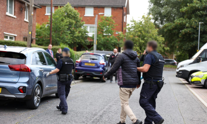 Police officers arrest a 40-year-old woman and a 26-year-old man in Belfast, Northern Ireland, UK, on Aug. 3, 2022. (PA Media/Home Office)