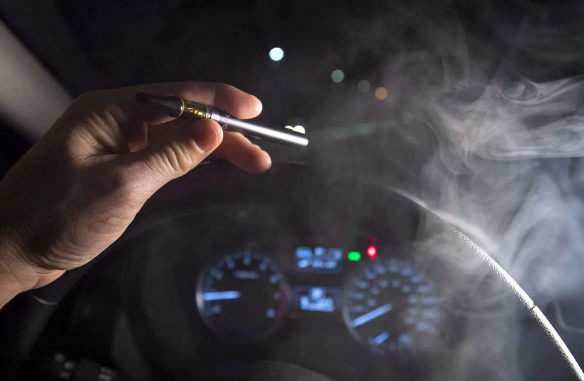 Smoke from a cannabis oil vaporizer is seen as the driver is behind the wheel of a car in North Vancouver, B.C., on Nov. 14, 2018. (Jonathan Hayward/The Canadian Press)