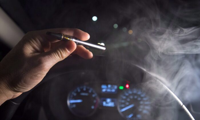 Smoke from a cannabis oil vaporizer is seen as the driver is behind the wheel of a car in North Vancouver, B.C., on Nov. 14, 2018. (Jonathan Hayward/The Canadian Press)
