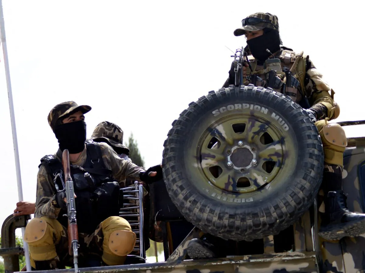 Taliban fighters patrol on the back of a vehicle along a road in Kandahar, Afghanistan, on March 15, 2022. (Javed Tanveer/AFP via Getty Images)
