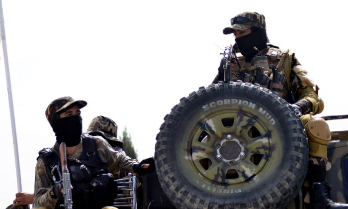 Taliban fighters patrol on the back of a vehicle along a road in Kandahar, Afghanistan, on March 15, 2022. (Javed Tanveer/AFP via Getty Images)