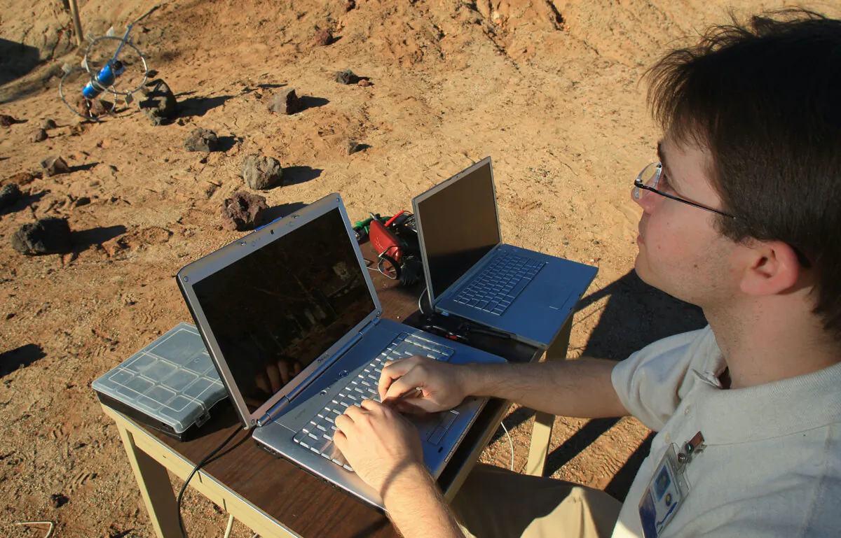 Caltech grad student Jeffrey Edlund remotely operates a rover on the grounds of the Jet Propulsion Mars Yard in Pasadena, Calif., on Jan. 14, 2009. (David McNew/Getty Images)