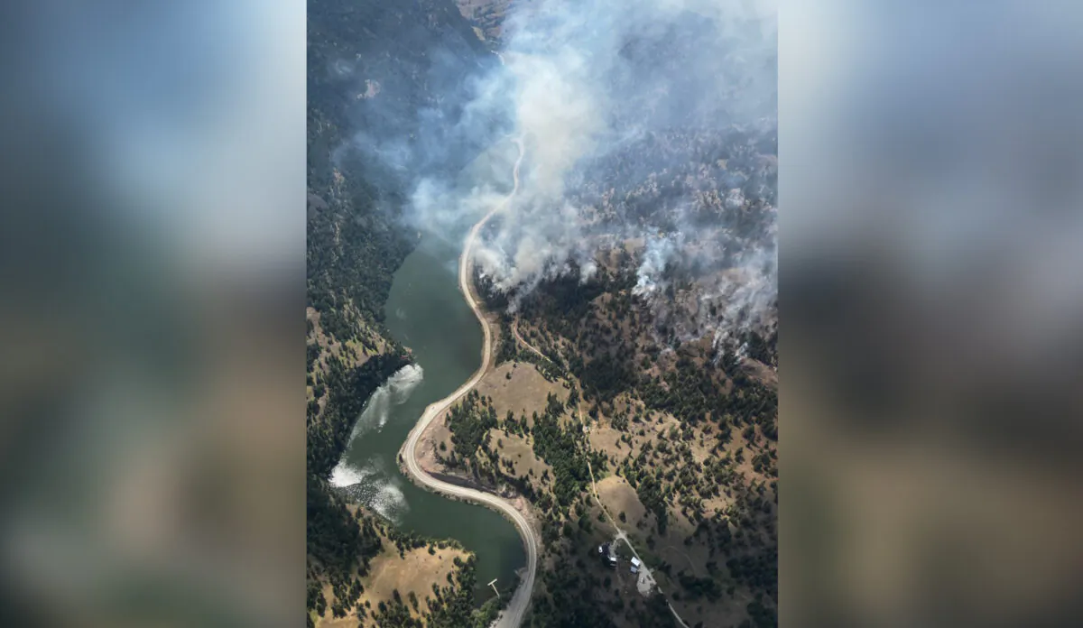 Smoke from a wildfire is visible along Highway 3A at the north end of Yellow Lake in British Columbia in an Aug.3, 2022 handout photo. (The Canadian Press/HO-BC Wildfire Service)