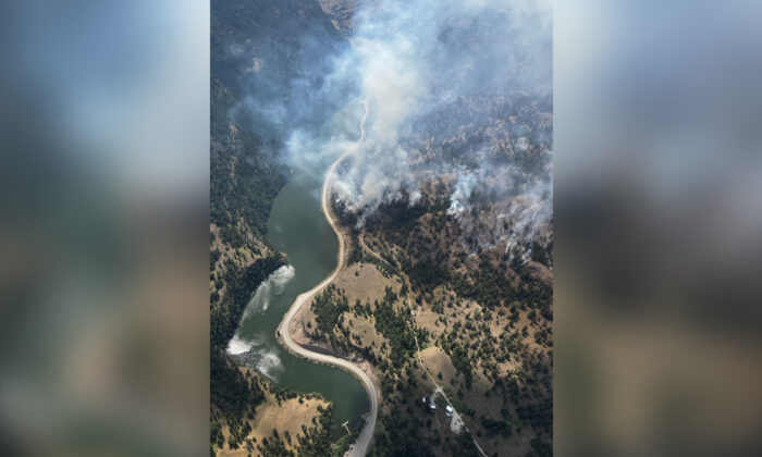 Smoke from a wildfire is visible along Highway 3A at the north end of Yellow Lake in British Columbia in an Aug.3, 2022 handout photo. (The Canadian Press/HO-BC Wildfire Service)