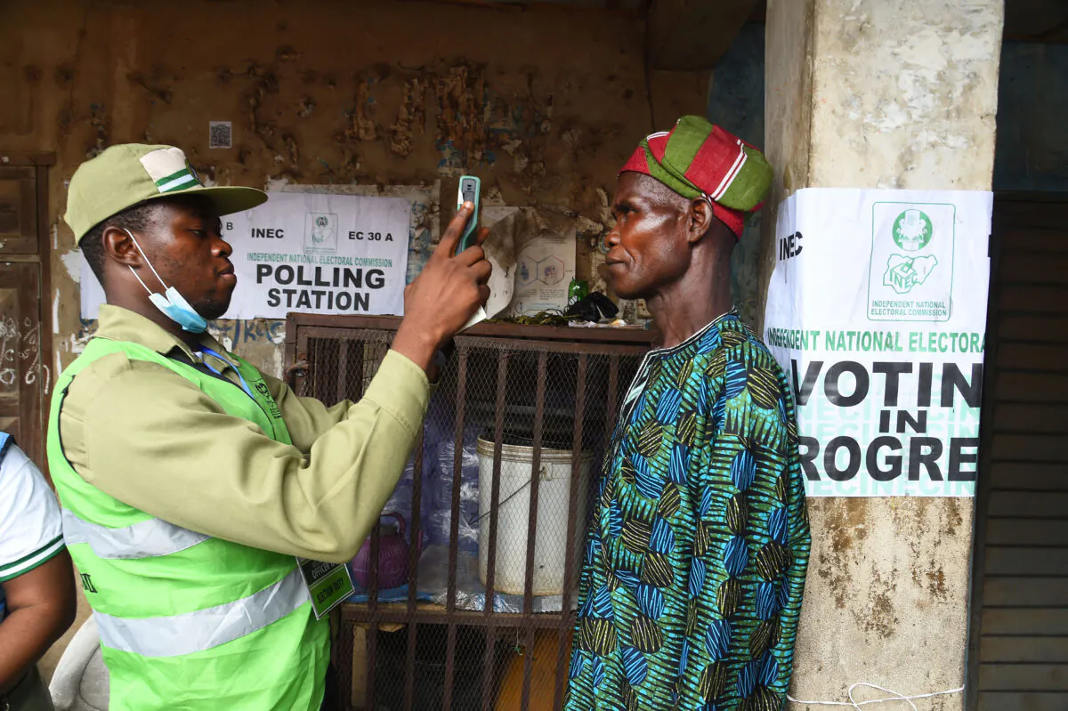 An official of the Independent National Electoral Commission (INEC) validates a voter at a polling station during the gubernatorial election at Ede in Osun State, southwest Nigeria, on July 16, 2022. Voters went to the polls to elect a new governor for Nigeria's southwest Osun state, in what has become a battleground to test support for the leading presidential hopefuls ahead of presidential elections in 2023. (Pius Utomi Ekpei/AFP via Getty Images)