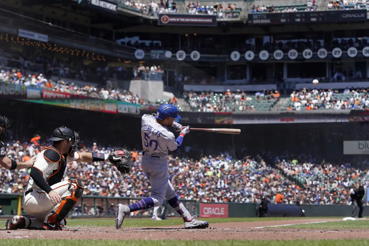 Los Angeles Dodgers' Mookie Betts (50) hits a three-run home run in front of San Francisco Giants catcher Austin Wynns during the fourth inning of a baseball game in San Francisco, Thursday, Aug. 4, 2022. (Jeff Chiu/AP Photo)