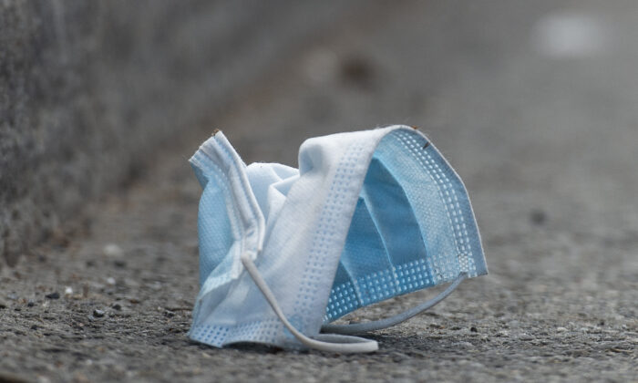 A disposable face mask is discarded on a street in Montreal, on April 18, 2021. (The Canadian Press/Graham Hughes)