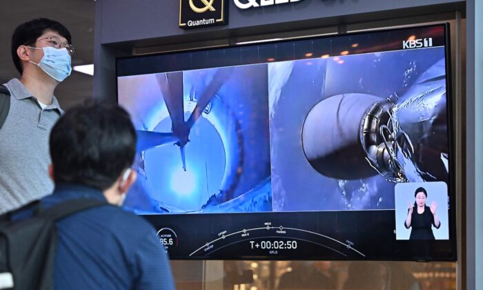2022 年 8 月 5 日，在首尔的一个火车站，人们观看电视屏幕，播放 SpaceX 猎鹰 9 号火箭从佛罗里达州卡纳维拉尔角搭乘韩国首个月球轨道飞行器 Danuri 发射的现场画面。（Jung Yeon-je/法新社）通过盖蒂图片）