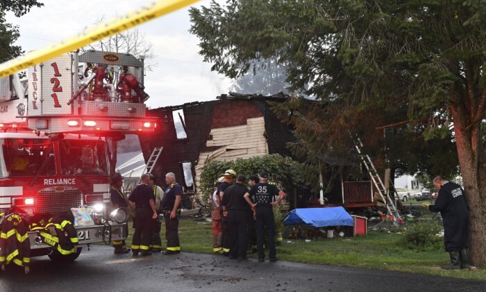 Firefighters gather next to a home after an early morning fatal fire at 733 First Street in Nescopeck, Pa., on Aug. 5, 2022. (Jimmy May/Bloomsburg Press Enterprise via AP)